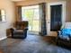 Inviting living room featuring comfortable armchairs, plush carpeting, and a view to the outside at 2132 40Th N Ave, St Petersburg, FL 33714