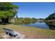 Scenic view of the neighborhood pond with surrounding trees and a peaceful bench at 2132 40Th N Ave, St Petersburg, FL 33714