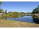Scenic view of a serene pond, surrounded by mature trees and lush greenery creating a peaceful environment at 2132 40Th N Ave, St Petersburg, FL 33714
