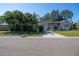 Street view of a single story house with lush landscaping, featuring palm trees and an American Flag at 2132 40Th N Ave, St Petersburg, FL 33714