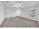 Spacious bedroom with neutral carpet, a ceiling fan, and two windows providing natural light at 22196 Calisto Way, Land O Lakes, FL 34637
