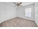 A bright bedroom featuring neutral carpet, ceiling fan, and a window at 22196 Calisto Way, Land O Lakes, FL 34637