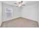 Cozy bedroom with neutral carpeting, a ceiling fan, and a large window for natural light at 22196 Calisto Way, Land O Lakes, FL 34637