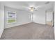 Expansive bedroom with plush carpeting, a ceiling fan, and large windows offering outdoor views at 22196 Calisto Way, Land O Lakes, FL 34637