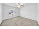 A bright bedroom featuring neutral carpet, ceiling fan, and a window with blinds at 22196 Calisto Way, Land O Lakes, FL 34637