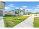Well-maintained front yard with lush green grass, sidewalk, and view of neighboring houses under a sunny sky at 22196 Calisto Way, Land O Lakes, FL 34637