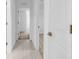 Bright hallway with white walls, doors and light tile flooring leading to the bedrooms at 22196 Calisto Way, Land O Lakes, FL 34637