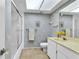 Bathroom with a glass-enclosed shower, a skylight, and blue and white bird-themed wallpaper at 2241 Shelly Dr # D, Palm Harbor, FL 34684