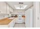 Bright kitchen featuring white cabinetry, appliances, wood countertops, and a skylight at 2241 Shelly Dr # D, Palm Harbor, FL 34684