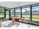 Bright sunroom featuring large windows, views of the community, and a cozy dining area at 2241 Shelly Dr # D, Palm Harbor, FL 34684
