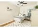 Cozy bedroom with a white bed, ceiling fan, and wood flooring topped with a plush white rug at 232 Columbia Dr, Tampa, FL 33606
