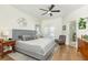 Relaxing main bedroom with wood floors, a ceiling fan, and a view of the ensuite bathroom at 232 Columbia Dr, Tampa, FL 33606