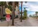 Beach access path with a building, trees, and signs including beach access and a stop sign at 248 137Th Cir, Madeira Beach, FL 33708