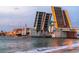 View of a drawbridge spanning the water with an illuminated roadway, a sailboat passing below at 248 137Th Cir, Madeira Beach, FL 33708