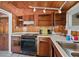 Rustic kitchen featuring wood walls, tile flooring, modern appliances and white countertops at 248 137Th Cir, Madeira Beach, FL 33708