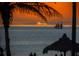 Picturesque ocean view, palm trees, with sailboat on the horizon during a vibrant sunset at 248 137Th Cir, Madeira Beach, FL 33708