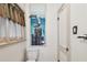 Bright bathroom features a low-flow toilet, a decorative painting and colorful window treatments at 251 72Nd Ave, St Pete Beach, FL 33706