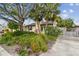 Charming home featuring a vibrant flower garden and mature trees enhancing its curb appeal at 251 72Nd Ave, St Pete Beach, FL 33706