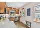 Eat-in kitchen offers stainless steel appliances, stone countertops, wood cabinets, and a stained glass window at 251 72Nd Ave, St Pete Beach, FL 33706
