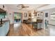 Inviting living room with hardwood floors, modern cabinet, ceiling fan, and seamless flow into the kitchen at 251 72Nd Ave, St Pete Beach, FL 33706