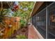 Charming outdoor brick patio area with beautiful tropical foliage, screened-in porch, and washer dryer hookups at 251 72Nd Ave, St Pete Beach, FL 33706