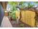 Side yard featuring a brick pathway, lush plantings, and a decorative fence, creating a serene outdoor space at 251 72Nd Ave, St Pete Beach, FL 33706
