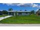 Charming single-story home featuring a well-maintained lawn and a quaint, inviting facade at 2801 Poinciana Ct, Punta Gorda, FL 33950