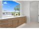Bathroom with a long double sink, white countertop, and a large window with a leafy view at 3406 W Alline Ave, Tampa, FL 33611