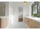 Bright bathroom with double sinks, mirrors, and a serene view from a big window at 3406 W Alline Ave, Tampa, FL 33611