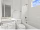 Bathroom with white vanity, toilet, tub, shower combo, and herringbone backsplash at 3406 W Alline Ave, Tampa, FL 33611