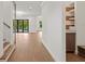 Spacious hallway featuring hardwood floors, white walls, and views into the back yard at 3406 W Alline Ave, Tampa, FL 33611