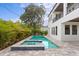 Backyard pool with spa, lush landscaping, and a two-story house at 3406 W Alline Ave, Tampa, FL 33611