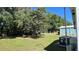 Spacious backyard with mature trees and lush green grass, offering a private outdoor space at 3829 Chah Dr, Zephyrhills, FL 33541