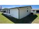 Exterior side view of a well-maintained home with manicured lawn and landscaping at 3829 Chah Dr, Zephyrhills, FL 33541