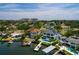 Aerial view of the waterfront property showing the pool, lush backyard, dock with boat lift, and surrounding area at 389 Bayview Ne Dr, St Petersburg, FL 33704