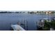 Wide view of dock and boat lift overlooking tranquil bay with distant homes and clear sky reflection at 389 Bayview Ne Dr, St Petersburg, FL 33704