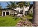 Charming entry to the property showcasing an elegant entrance and beautifully landscaped front yard with colorful flowers at 389 Bayview Ne Dr, St Petersburg, FL 33704