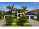 Beautiful two-story home with a black metal roof, white stucco, three-car garage and mature palm tree landscaping at 389 Bayview Ne Dr, St Petersburg, FL 33704
