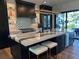 Modern kitchen with black cabinets, designer backsplash, and a waterfall island with seating at 389 Bayview Ne Dr, St Petersburg, FL 33704