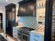 Gourmet kitchen featuring stainless steel appliances, custom cabinetry, and stylish tile backsplash at 389 Bayview Ne Dr, St Petersburg, FL 33704