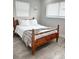 Cozy bedroom showcasing a wooden frame bed, soft white bedding, a plaid throw blanket, and natural light from two windows at 428 45Th N Ave, St Petersburg, FL 33703