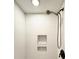 Bright shower featuring white tiles with textured design and shower niche, paired with a modern shower head and fixtures at 428 45Th N Ave, St Petersburg, FL 33703