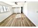 Bright bedroom featuring modern wood-style tile floor, ceiling fan, and shuttered windows at 502 Palm Dr, Largo, FL 33770