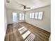 Bright bedroom featuring modern wood-style tile floor, ceiling fan, and shuttered windows at 502 Palm Dr, Largo, FL 33770
