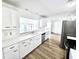 Spacious kitchen featuring white cabinets, countertops, stainless steel appliances and wood-style tile floors at 502 Palm Dr, Largo, FL 33770