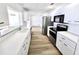 Bright and modern kitchen featuring white cabinets, countertops, and stainless steel appliances at 502 Palm Dr, Largo, FL 33770