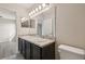 Bathroom with double vanity sink with granite countertop and a large well lit mirror at 5022 Chipotle Ln, Wesley Chapel, FL 33544