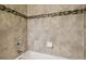 Well-lit bathroom featuring neutral-toned tiles accented by a decorative mosaic tile border at 5022 Chipotle Ln, Wesley Chapel, FL 33544
