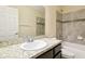 Bathroom featuring granite vanity top, tiled tub-shower, and mirrored medicine cabinet at 5022 Chipotle Ln, Wesley Chapel, FL 33544