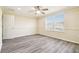 Neutral colored bedroom with wood-look floors, ceiling fan, and bright natural light at 5022 Chipotle Ln, Wesley Chapel, FL 33544